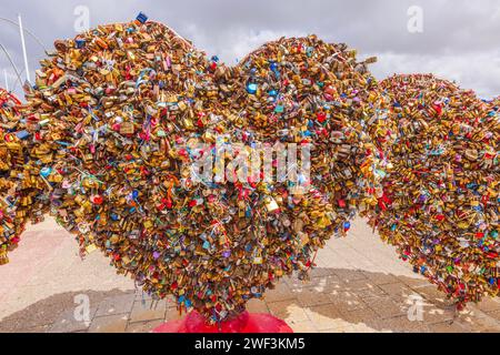 Heart-shaped symbols adorned with padlocks tell tales of enduring love. Willemstad. Curacao. Stock Photo