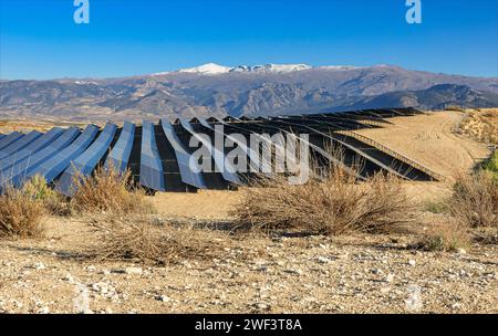 A field of Solar panels against the backdrop of the Sierra Nevada Mountains in the evening sunshine Stock Photo