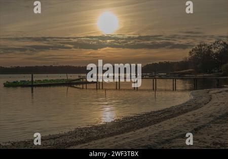 Early evening as the sun goes down over a lake and is reflected in the water Stock Photo