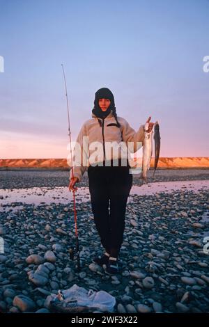 woman with Arctic char, Salvelinus alpinus, catch in the central Arctic, North Slope of the Brooks Range, Alaska Stock Photo