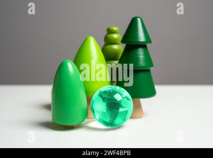Forest and blue globe. Wooden tree figurines. Conservation of forests and nature reserves. Innovative technologies to reduce the impact on the environ Stock Photo