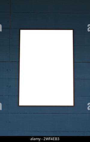 Empty picture frames on a dark wooden blue wall for design and ideas in your work. Stock Photo