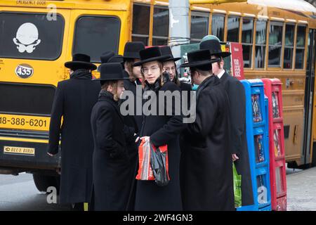 A group of orthodox Jewish students wait for a bus to transport them to a Talmud class on the other side of Brooklyn, New York. Stock Photo