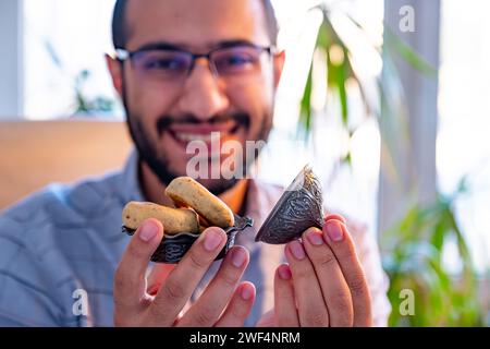 male holding eid sweets with smile on his face in office Stock Photo