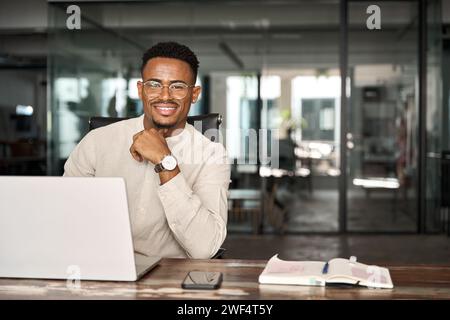 Happy professional African business man looking at camera at work, portrait. Stock Photo