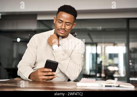 Busy African American business man working in office using cellphone. Stock Photo