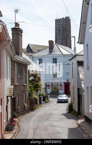 The A379 passing through Stoke Fleming with St Peters Church Tower above the houses, Devon, England Stock Photo