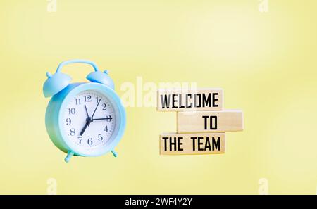 Concept words Welcome to our team on wooden blocks. Beautiful yellow background. Copy space. Stock Photo