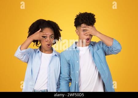 Shocked and surprised young African American couple making fun faces with hands on their faces Stock Photo