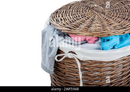 Overflowed Wicker basket with laundry isolated  on white background. Wooden basket full of clothes. Stock Photo