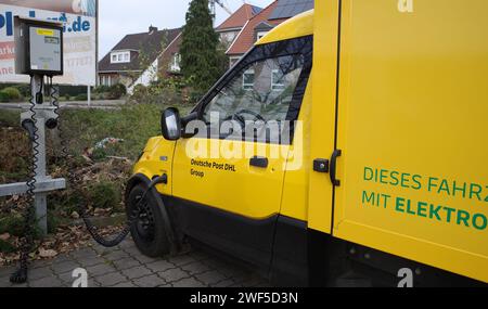 Wietmarschen, Germany Dec 3 2023 A all electric van of DHL is being  charged. DHL is an American-founded German logistics company providing courier, p Stock Photo