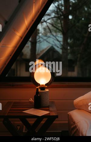Small table with a window-lit lamp Stock Photo