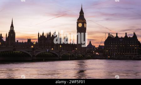 London, UK. 28th Jan, 2024. The Elizabeth Tower, commonly known as Big Ben, and Houses of Parliament on the Thames are silhouetted against the sky and setting sun. The London Eye is softly backlit as the sun is setting. A beautifully sunny day in London ends with clear skies and milder temperatures at sunset. Credit: Imageplotter/Alamy Live News Stock Photo