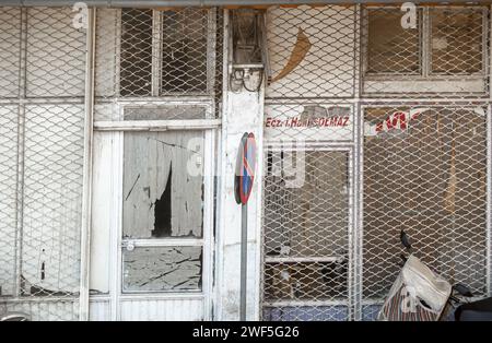 Shabby closed business store front building, metal grid closed with holes Sanliurfa Turkey Stock Photo