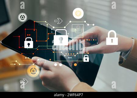 Privacy protection. Woman using tablet in office, closeup. Digital scheme with padlocks over device Stock Photo