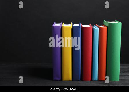 Different books on gray wooden table against dark background, space for text Stock Photo