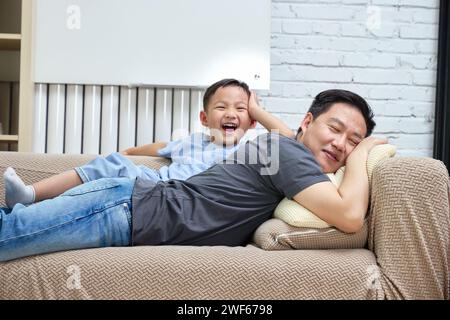 Intimate father and son lying together on the sofa Stock Photo