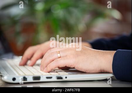Hands of a middle-aged man using a laptop Stock Photo
