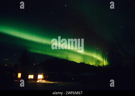 northern lights, Aurora borealis, over a cabin home in the village of Wiseman, south side of the Brooks Range, Alaska Stock Photo