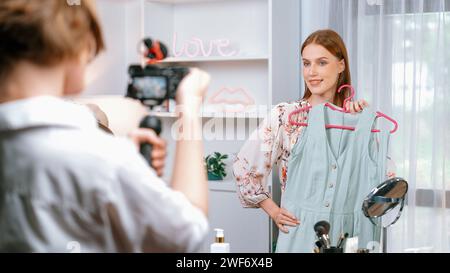 Woman influencer shoot live streaming vlog video review clothes utmost social media or blog. Happy young girl with apparel studio lighting for Stock Photo