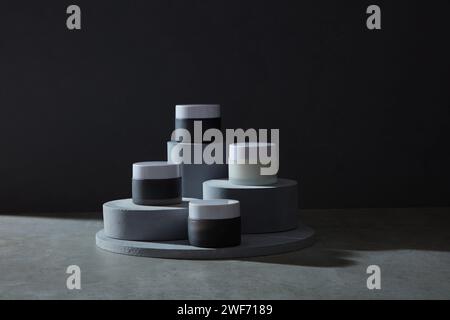 Geometric shapes podium for product display. Monochrome platform on black background. Minimal style. Front view. Stock Photo