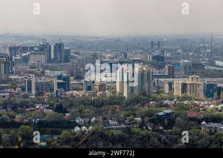 Panoramic view on Almaty from mount Kok Tobe park. Cityscape at spring day. Haze smog above town, ecology problem. Republic of Kazakhstan, Central Asi Stock Photo