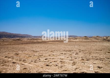 Expansive view of the arid Judean Desert terrain under the bright blue sky, near the Dead Sea in Israel. Stock Photo