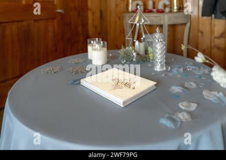 A reception table captures attention with its 'Mr & Mrs' guestbook, surrounded by soft candlelight and decorative accents, ready for guests Stock Photo