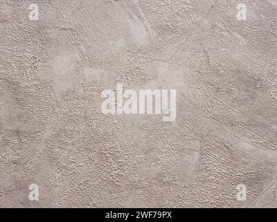 Abstract textured beige stucco wall background or backdrop. Seamless material wallpaper with rough vintage, weathered and grunge outlook. Design paper Stock Photo