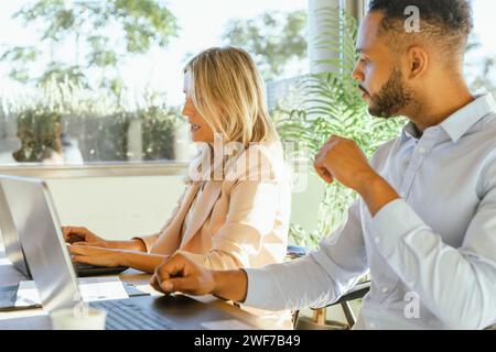 Businesswoman showing something and asking for consultation to her work colleague. Business concept. Stock Photo