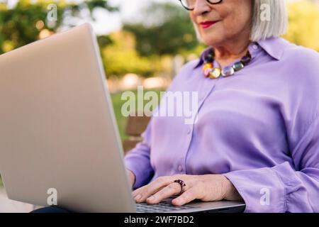 unrecognizable senior woman typing on laptop Stock Photo