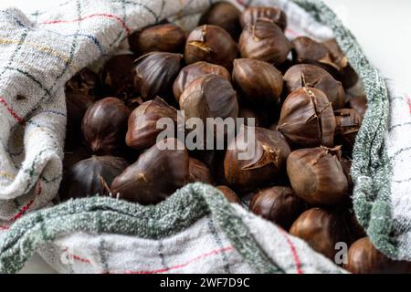 A pile of hot roasted chestnuts wrapped in a towel Stock Photo