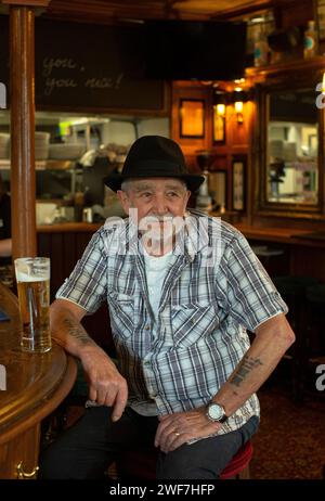 Middle aged man drinking a pint of beer alone in a pub Stock Photo