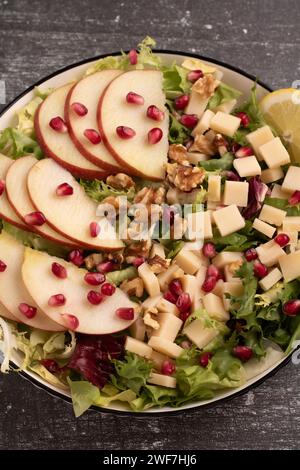 plate with apple, greens, walnuts, cheese, and pomegranate seeds Stock Photo