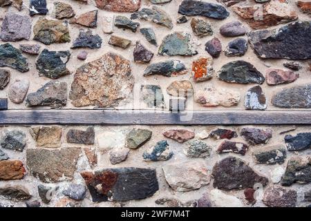 vintage stone masonry with wooden stripe in the middle. ancient architectural background Stock Photo
