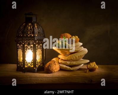 Middle Eastern cuisine Falafel and Khuboos with Ramadan lantern. Beautiful Ramadan food photo or still life. Iftar food photo. Stock Photo