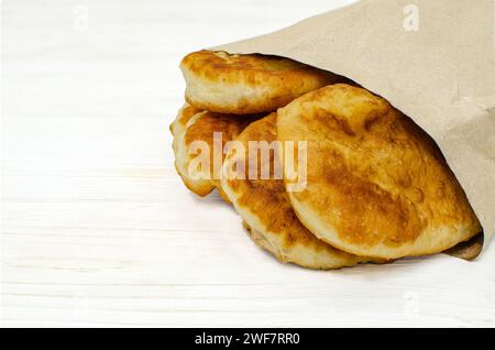 Assortment of  pastries in paper ecological bags on a white wooden background Stock Photo