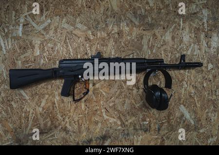 Kalashnikov AK 74m assault rifle in a shooting range on the wall and safety glasses and headphones. High quality photo Stock Photo