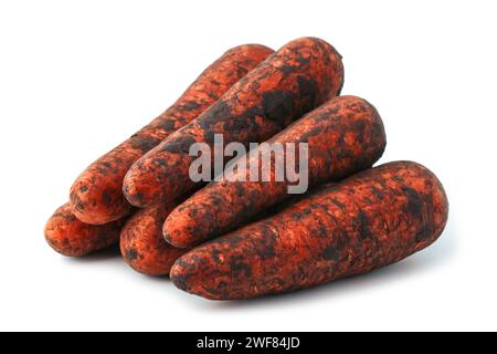 Dirty unwashed carrots after harvesting in a stack isolated on a white background Stock Photo