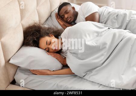 Young black married couple sleeping calmly together lying in bedroom Stock Photo