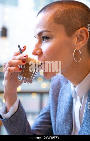 Vertical portrait side view stylish woman drinking coffee in cafe Stock Photo