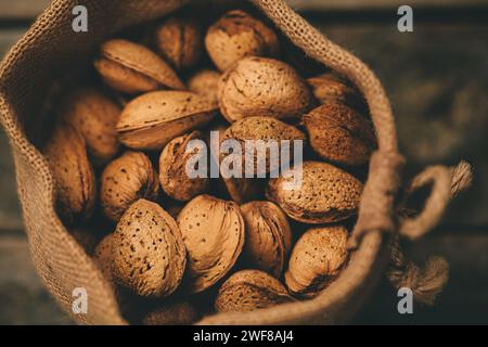 A collection of textured almonds nestled in a coarse fabric bag, emphasizing natural simplicity Stock Photo