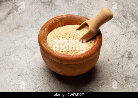 Bread crumbs and a wooden scoop in a wooden bowl on a kitchen countertop in a top view Stock Photo