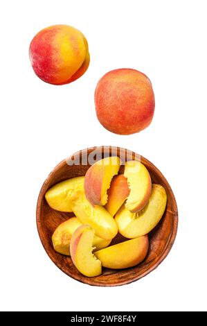 Sliced Peaches, organic fruit in a wooden bowl. Isolated on white background. Top view Stock Photo