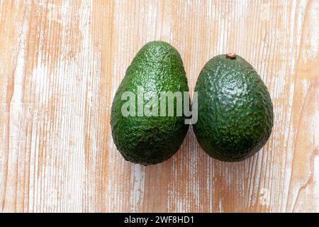 two avocados on wooden background Stock Photo