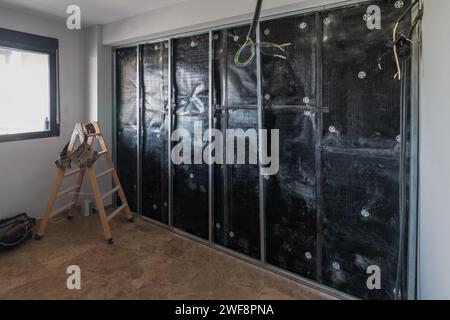 Installing insulation into interior partition wall Stock Photo - Alamy