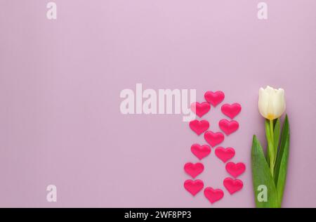 8 March, International Women's Day, Figure eight made with hearts and tulip on pink background. Stock Photo