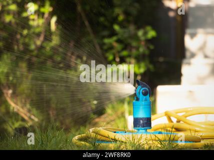 Automatic sprinkler system watering the lawn in the garden. Close-up. Stock Photo