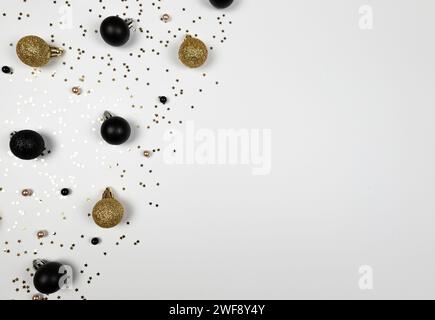 Christmas composition, black and gold decorations, black and gold baubles, gold stars confetti on white background. Stock Photo