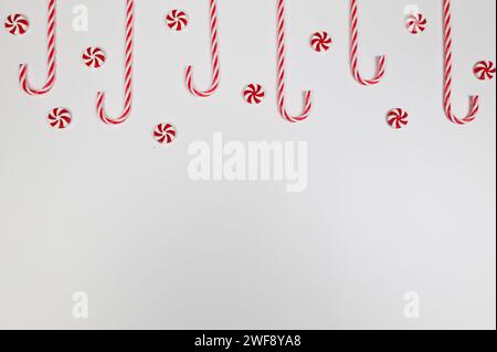 Christmas composition, red and white sweets, candy canes, round candies on white background. Christmas, New Year, winter concept. Stock Photo